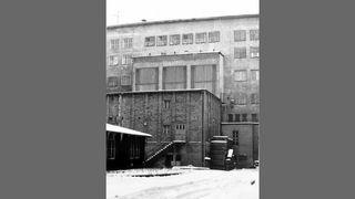 Schwarz-weiß-Aufnahme mit Blick aus dem Innenhof auf die baufällige Rückseite des Hauptgebäudes im Jahr 1986. Damals stand dort noch ein Anbau.
