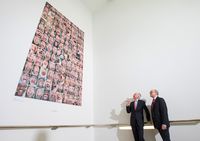 Rechts Claus Ludwig Meyer-Wyk, Vorsitzender des Freundeskreises Deutsches Hygiene-Museum e. V., und links Prof. Klaus Vogel, Direktor des Deutschen Hygiene-Museums, vor der vom Freundeskreis angekauften Fotoarbeit Schrei der Künstlerin Herlinde Koelbl. Das Werk zeigt viele Gesichter mit offenen Münder.