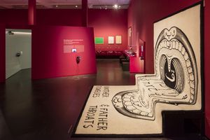 Ein großer weißer Teppich im roten letzten Raum der Ausstellung Sprache mit arabischen Ornamenten und stilisiertem menschlichen Rachen.