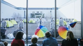 Perforance des Theaters Junge Generation auf dem Museumsinnenhof mit bunten Schirmen und Zelten