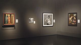 Zwei Gemälde und zwei Fotografien an einer hellgrauen Wand. Die Gemälde und Fotografien haben Schwangerschaft zum Thema. Auf den schwarz weiß Fotografien in der Mitten ist jeweils eine schwangeren Frau. Die Gemälde rechts und links sind antike Ölgemälde.