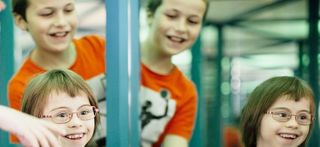 Ein Mädchen mit Down-Syndrom im Spiegelkabinett des Kinder-Museums