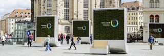 Auf dem Neumarkt stehen vier vertikal bepflanzte Stelen auf denen &quot;Dresden concept&quot; steht. Die Füße der Stele sind Sitzbänke.