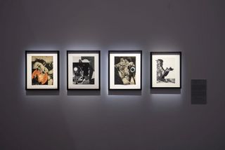 An einer schwarzen Wand hängen vier beleuchtete Bilder, auf denen Fotocollagen mit der Sonne als Motiv abgebildet sind. 