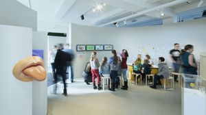 Erwachsene und Kinder an Kreativtischen im Kinder-Museum. Im Vordergrund ein großes Zungen-Modell.